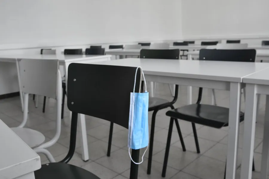 Empty classroom with a face mask hanging on a chair