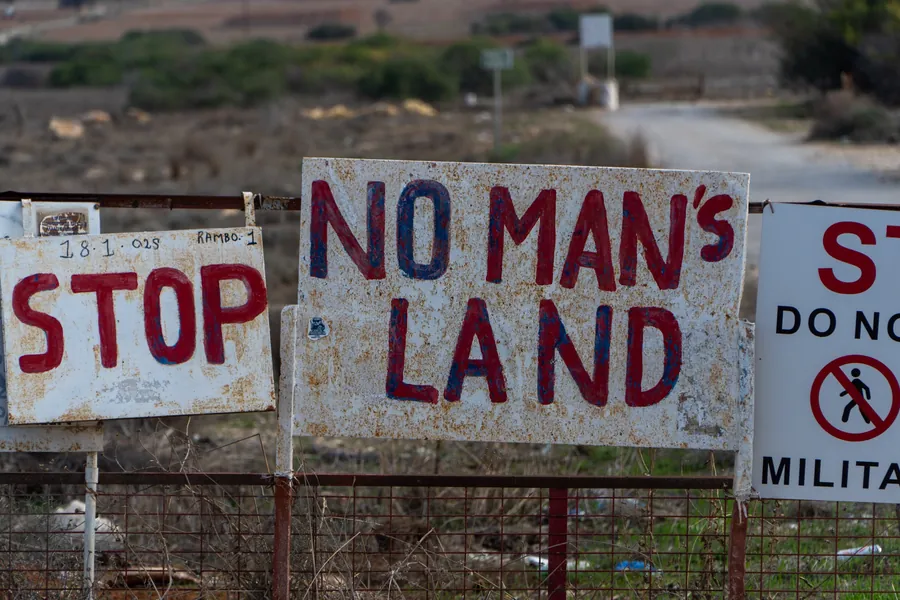 Hand-painted signs: Stop, No man’s land