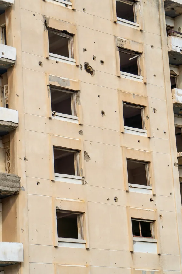 A facade marked by bullet holes