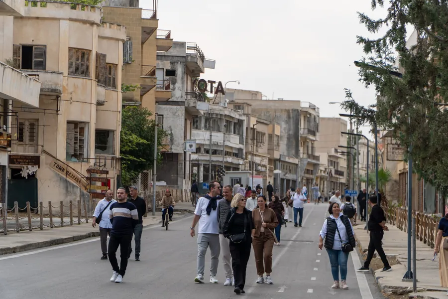 Tourists walking down a street of abandoned buildings