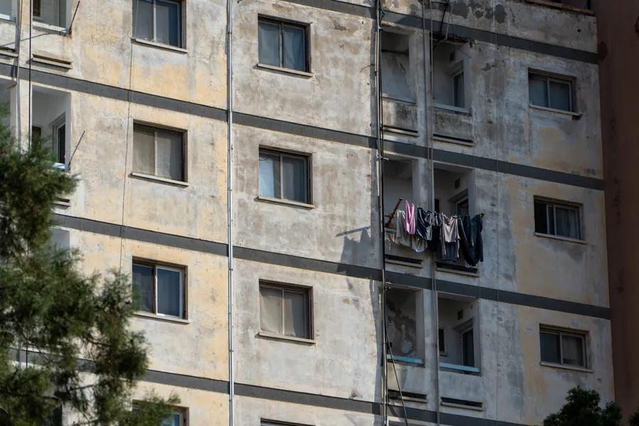 Laundry hanging from a balcony of a weathered apartment block